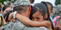 Una chica joven abraza a su padre después de una ceremonia de redistribución