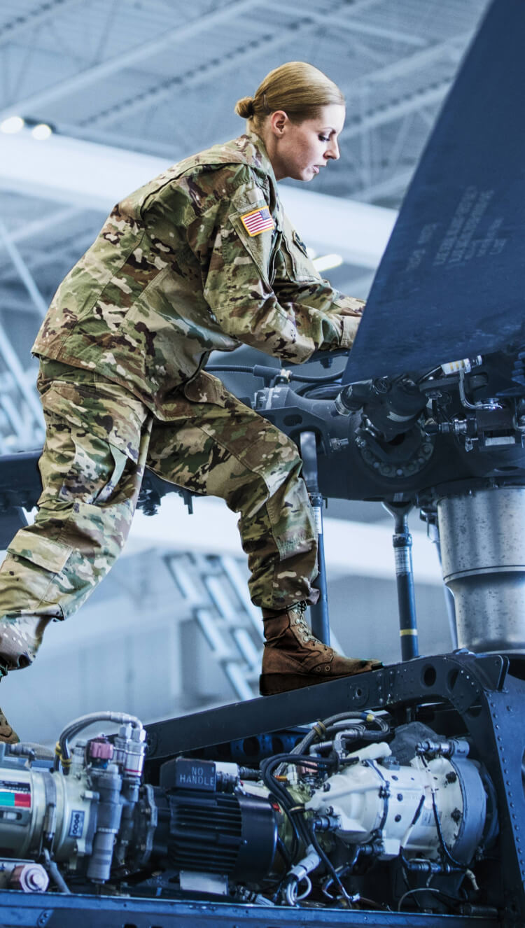 Army mechanic repairing aircraft.